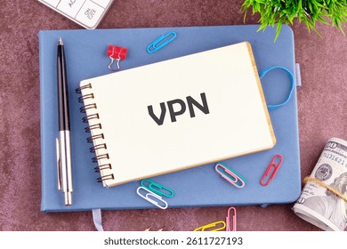 A notepad featuring the abbreviation VPN is set on a desk surrounded by colorful stationery clips, a pen, and a stack of cash in a productive workspace.