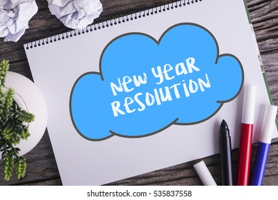 Notepad And Green Plant On Wooden Background With New Year Resolution Word