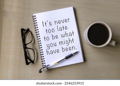 Notepad and inspirational quote It's never too late to be what you might have been. - Powered by Shutterstock