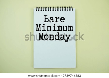 Notepad with message "Bare Minimum Monday" top view on yellow background