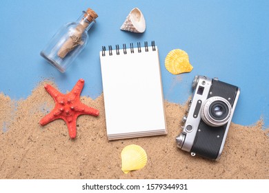 Notepad on the sand flat lay background. Sea vacation diary mockup. Summer to do list template.