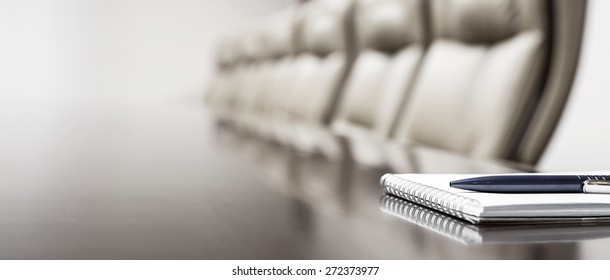 Notepad On Table In Empty Conference Room With Copy Space