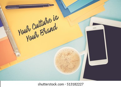 Notepad On Workplace Table And Written YOUR CULTURE IS YOUR BRAND Concept