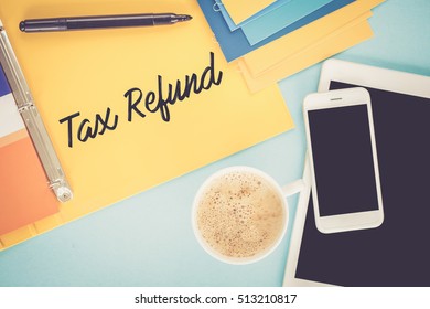 Notepad on workplace table and written TAX REFUND concept
