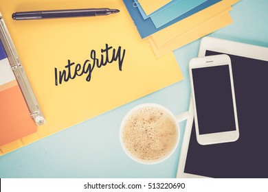 Notepad on workplace table and written INTEGRITY concept