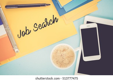 Notepad on workplace table and written JOB SEARCH concept