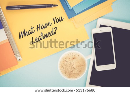 Notepad on workplace table and written WHAT HAVE YOU LEARNED? concept