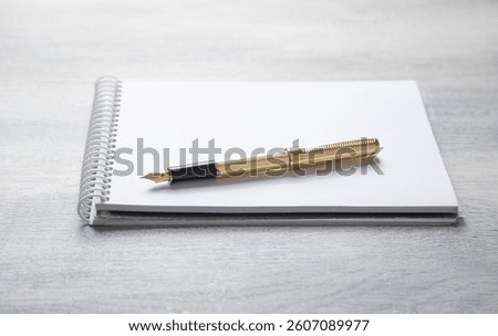 Notepad, pen, with a different business objects on the table.