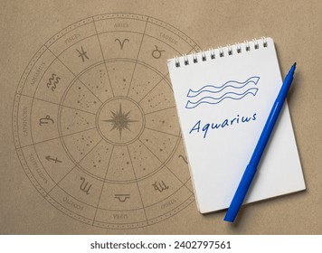 Notepad with pen and drawing of zodiac sign Aquarius