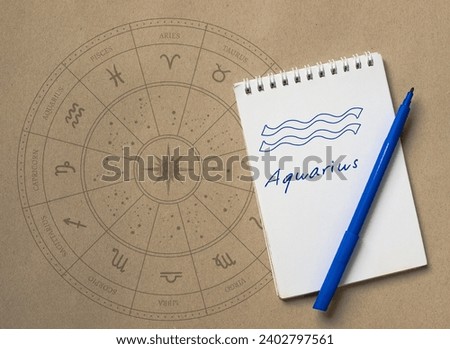 Notepad with pen and drawing of zodiac sign Aquarius