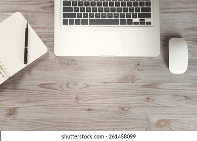 Notepad, Pen, Laptop And Mouse On Old Wooden Desk. View From Above With Copy Space In Vintage Tone.