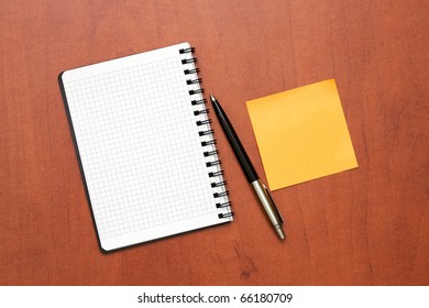 notepad with pen and reminder note lying on the table