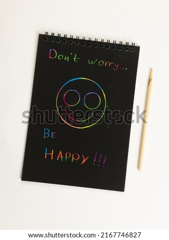 Notepad with sheets of black paper and colored inscription 