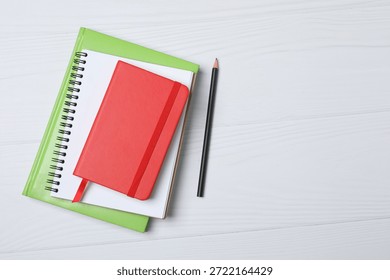Notepad with spring on the table with pencil and coffee. Office concept. Top view.
