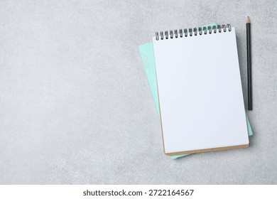 Notepad with spring on the table with pencil and coffee. Office concept. Top view.
