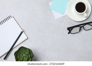 Notepad with spring on the table with pencil and coffee. Office concept. Top view.
