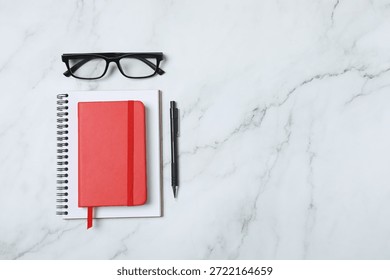 Notepad with spring on the table with pencil and coffee. Office concept. Top view.
