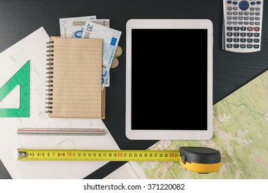 Notepad, tablet and tools for construction budget calculation. Economy on construction project. Work from home. How to make money. Small home business. Marketing. How to start a business. Top view.