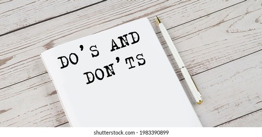 Notepad with text DO'S AND DON'TS. White background. Business concept