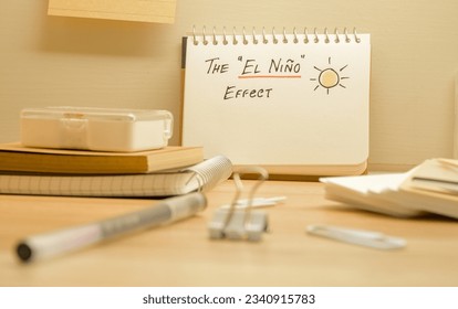 Notepad with the text the El Nino effect and hand drawing sun on desk. Climate change concept. 
