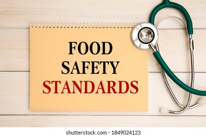 Notepad With Text Food Safety Standards On The Office Desk And Stethoscope