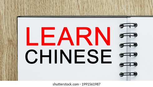 Notepad with text Learn Chinese on wooden deskt. study and education concept