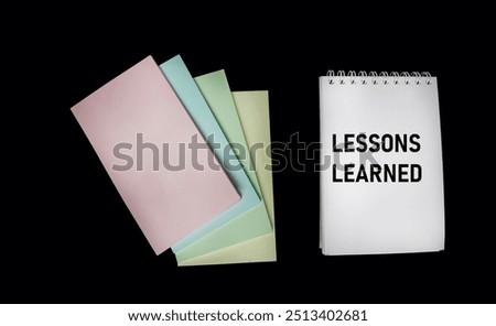 Notepad with text lessons learned on a black background. Business concept.