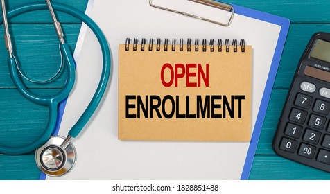 Notepad with text OPEN ENROLLMENT, calculator and stethoscope. Medical concept.
