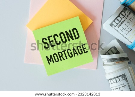 Notepad with text Second Mortgage lying on financial tables with a money