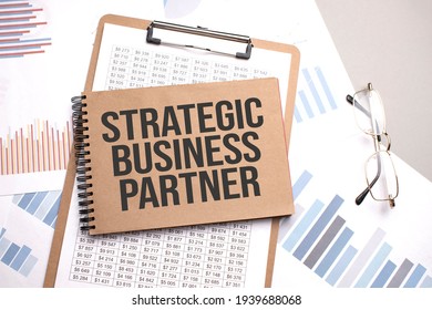 Notepad With Text STRATEGIC BUSINESS PARTNER On A Charts And Numbers. Business Concept.