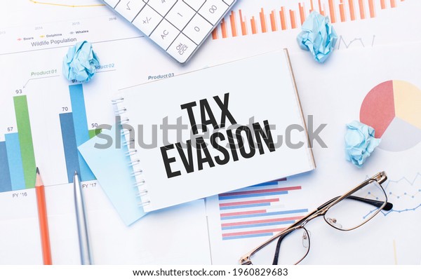 Notepad with text tax evasion on the
business charts and
pen,business