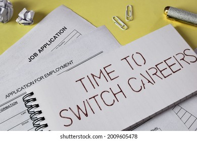A notepad with the text TIME TO SWITCH CAREERS laid on yellow background with job application forms. Concept of trying new employment opportunities, selective focus. 