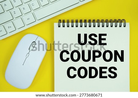 Notepad with the text "Use Coupon Codes" and white keyboard and wireless mouse on yellow background