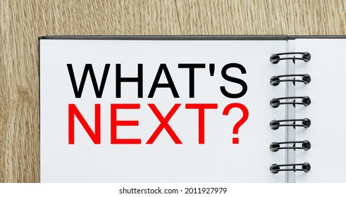 Notepad with text what is next on wooden deskt. Business and finance concept