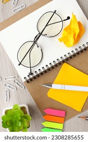 Notepad, white pen, calculator, glasses on a wooden background. Working space. flat lay, top view - Shutterstock ID 2308285655