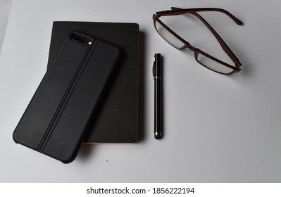 Note,pen,glasses and phone on the white background