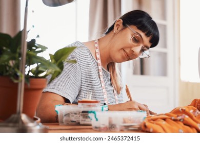 Notes, woman and writing with fashion designer in home studio for style with measuring tape for profession. Tailoring, couture and material or fabric for handmade clothing for business in Sweden. - Powered by Shutterstock