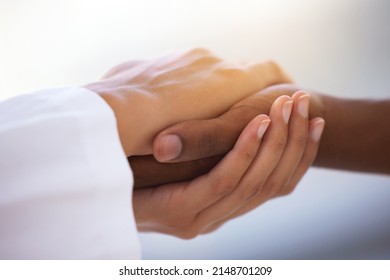 Nothing So Healing As The Human Touch. Shot Of An Unrecognizable Doctor Holding Hands With Her Patient During A Consultation.