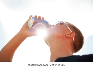 Nothing refreshes better than a cold beer. Closeup of a young man wearing sunglasses drinking a beer outside. - Powered by Shutterstock