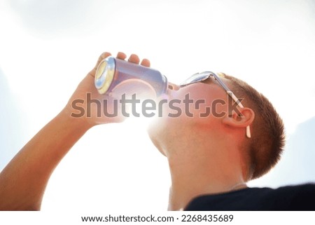 Nothing refreshes better than a cold beer. Closeup of a young man wearing sunglasses drinking a beer outside.