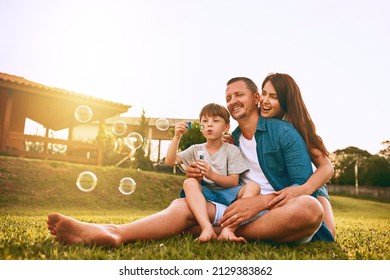 Nothing says family fun like blowing bubbles. Cropped shot of a young family spending time together outdoors. - Powered by Shutterstock