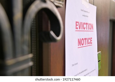 the notice of eviction of tenants hangs on the door of the house, front view - Shutterstock ID 1927117460