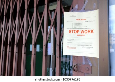 A Notice Has Been Posted In Front Of A Building Ordering The Premises To Stop Work Immediately.