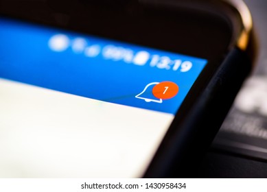 Notification bell button on smartphone app screen closeup