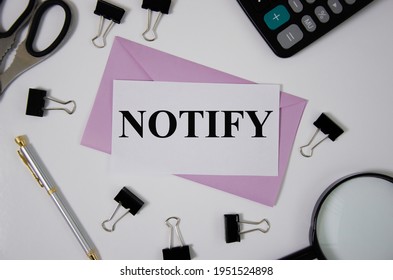 Notify Word Written On Pink Envelope Near Office Supplies. Word