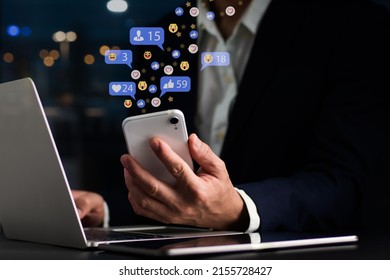 The notion of social media and digital internet, A guy uses his smartphone to access social media. The notion of work and play, as well as social media play Work from home idea, social distance - Shutterstock ID 2155728427