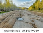 The notorious Russian roads. This is a spring highway with broken asphalt, so the car drives on dirt roadsides. The evolution of roads when the shoulder turns into the main lane