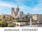 Notre Dame Cathedral and its iconic spire before the fire on April 15, 2019, and the statue of St. Genevieve, the patron saint of Paris, on a summer afternoon in Paris, France.