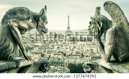 Notre Dame de Paris with gargoyles overlooking Paris city, France. Old cathedral with historic demon statues is World landmark. View of Eiffel Tower from gargoyles. Travel and vintage chimeras theme