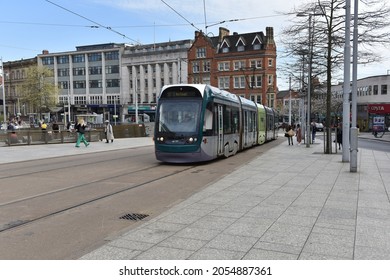 Nottingham, England – October 08, 2021: The moder tram in Nottingam passes the tram stop Old Market Square in Nottingham city centre near to the Nottingham Council House. 